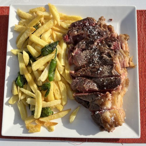 Filete de lomo alto laminado con papas fritas y pimientos de padrón
