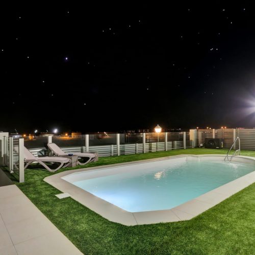 Piscina iluminada de la villa con cielo estrellado en Fuerteventura