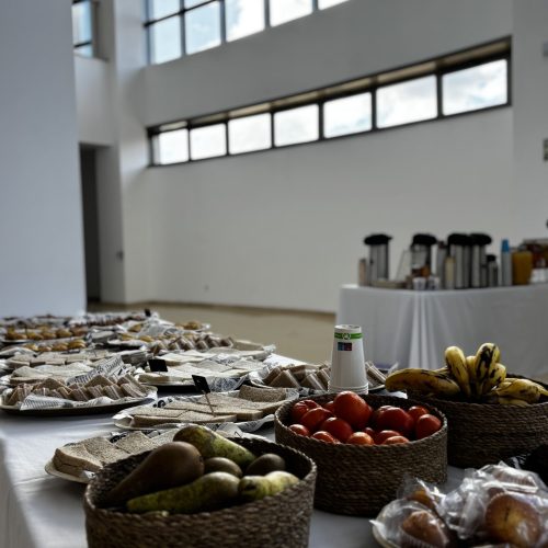 Buffet con bandejas de comida y cestas de frutas en salón de eventos de La Puipana