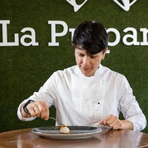 Cocinera de La Puipana emplata un bocado gourmet en la cocina del restaurante