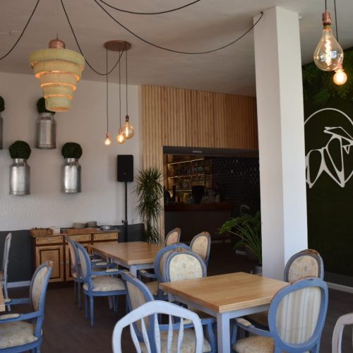 Sala de Restaurante La Puipana con mesas de madera y pared con logo de cabra